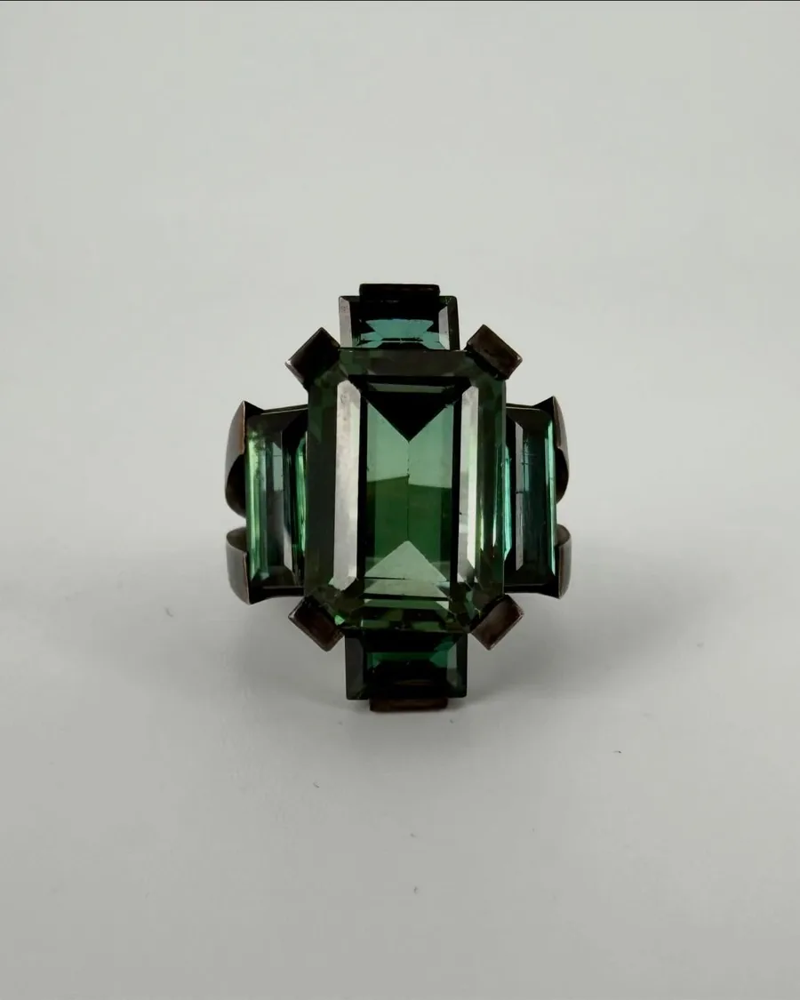 Ring: Brünierte Bronze, ein tiefgrüner Turmalin im Rechteckschliff, flankierende Steine.