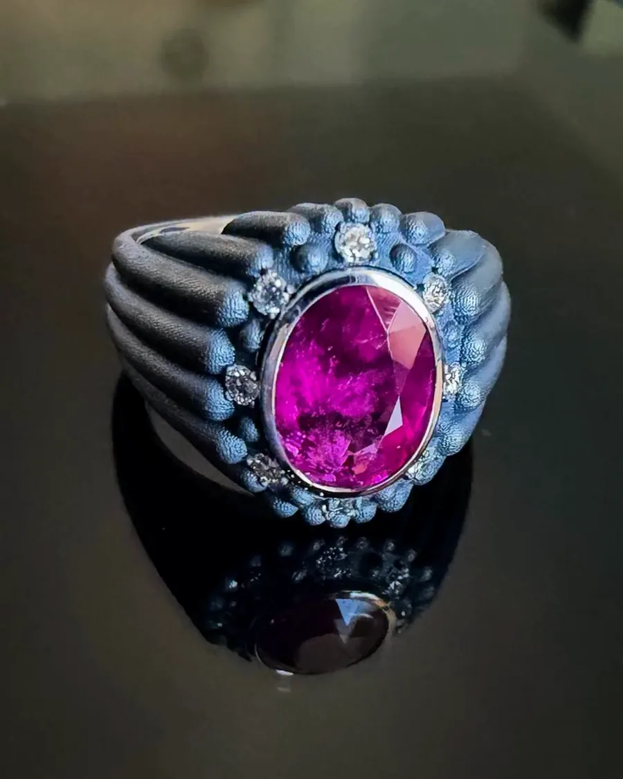 Ring: Geschwärztes Platin, ein ovaler rot-rosa Turmalin, Diamanten.