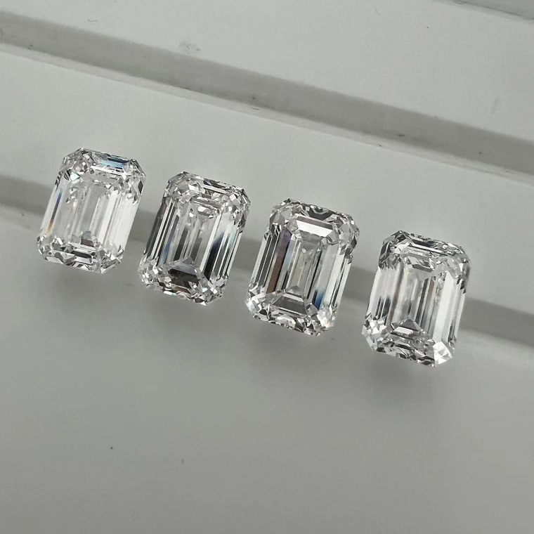 Four loose emerald cut diamonds before setting