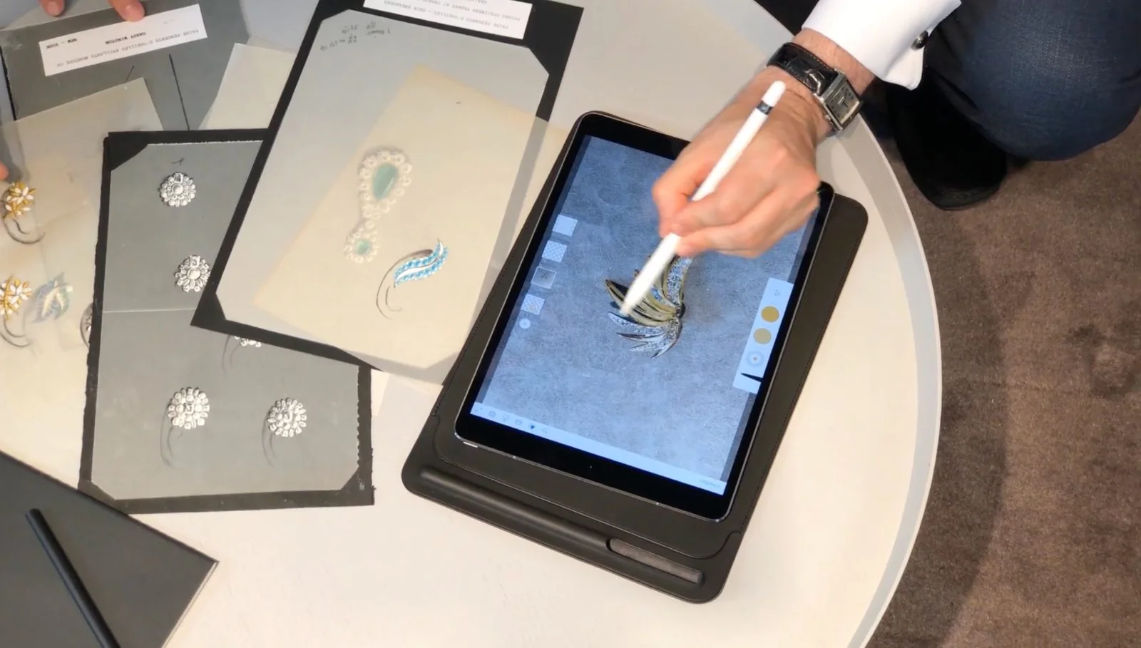 Entwurfsbögen und iPad auf dem Ateliertisch