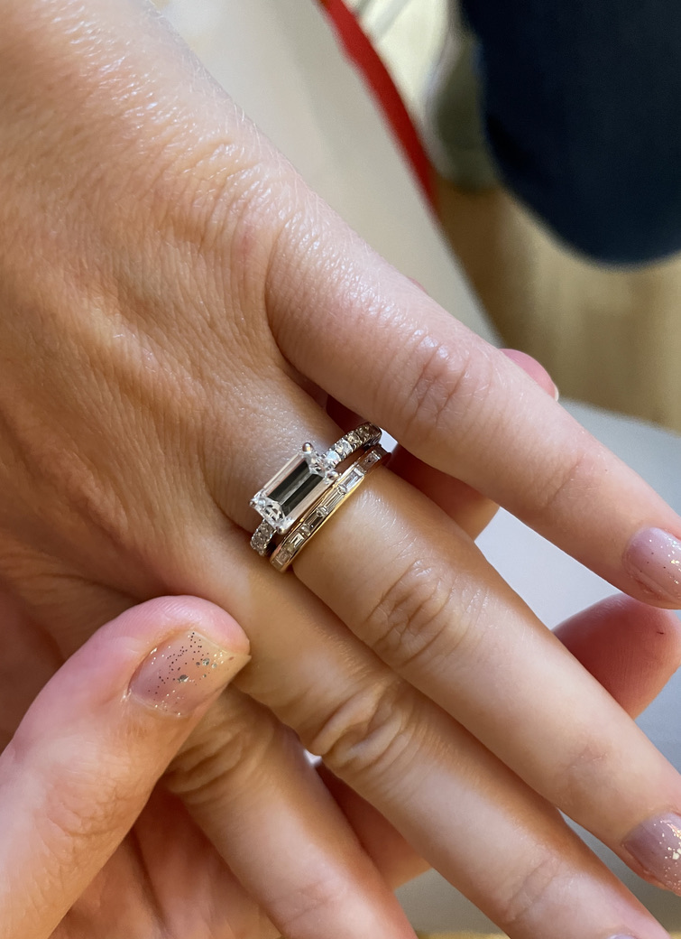 Emerald-Cut-Ring in Weißgold neben einem Gelbgoldring mit Pavé, zwei Metalle kombiniert