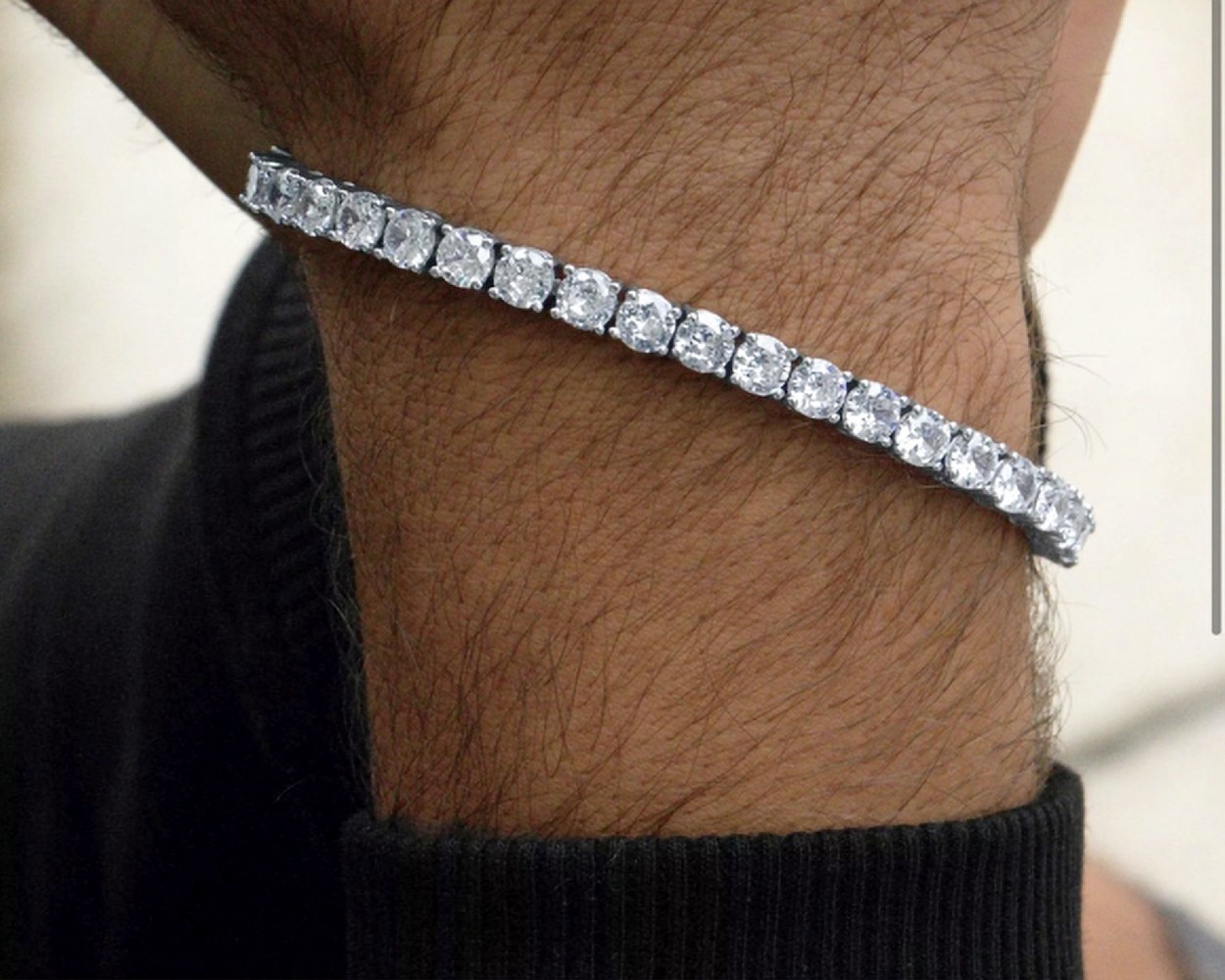 Weißes Diamant-Tennisarmband am Handgelenk eines Mannes
