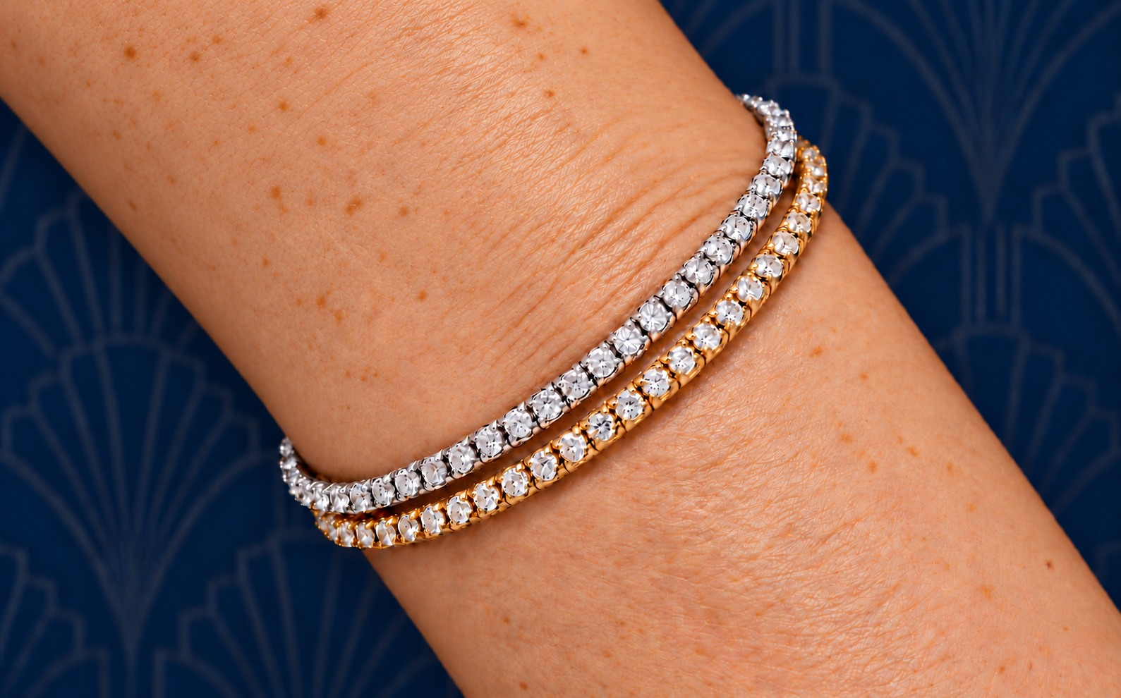 Infini: zwei Stretch-Tennisarmbänder nebeneinander am Handgelenk, Weißgold und Roségold